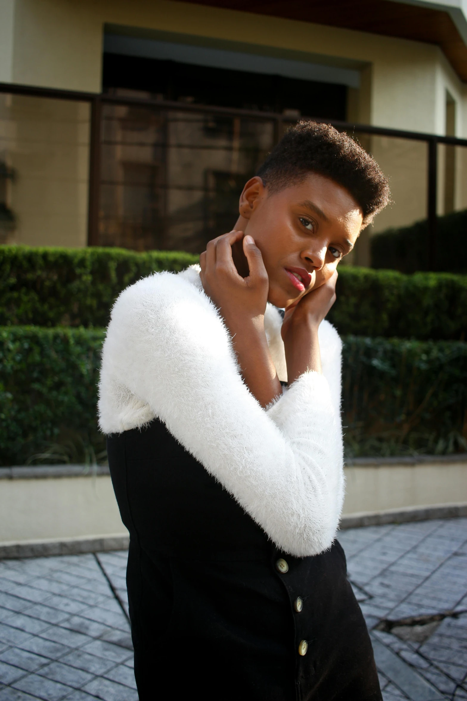 a woman in a black dress talking on a cell phone, wearing a white sweater, maria borges, androgynous male, posing for a picture