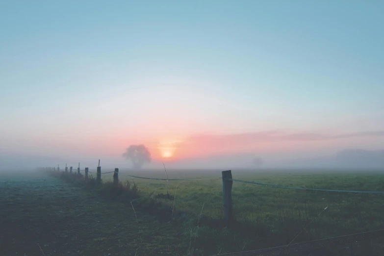 a foggy field with a fence in the foreground, pexels contest winner, pastel colored sunrise, instagram post, background image, sun down