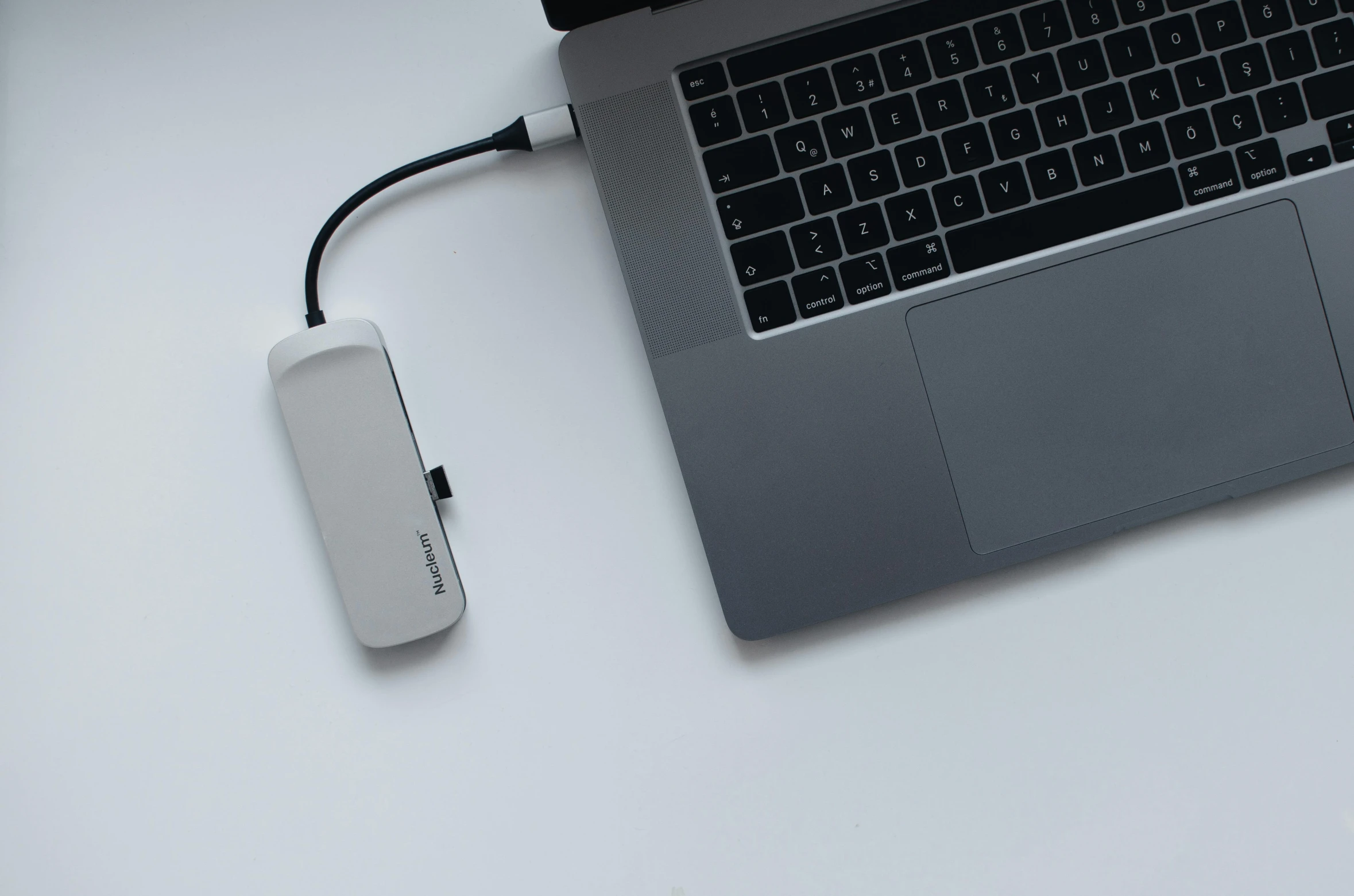 a laptop computer sitting on top of a white desk, holding a battery, waneella, medibang, connecting lines