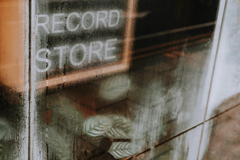 a store window with a sign that says record store, an album cover, inspired by Elsa Bleda, pexels contest winner, grainy texture, background image, alessio albi, high quality photo