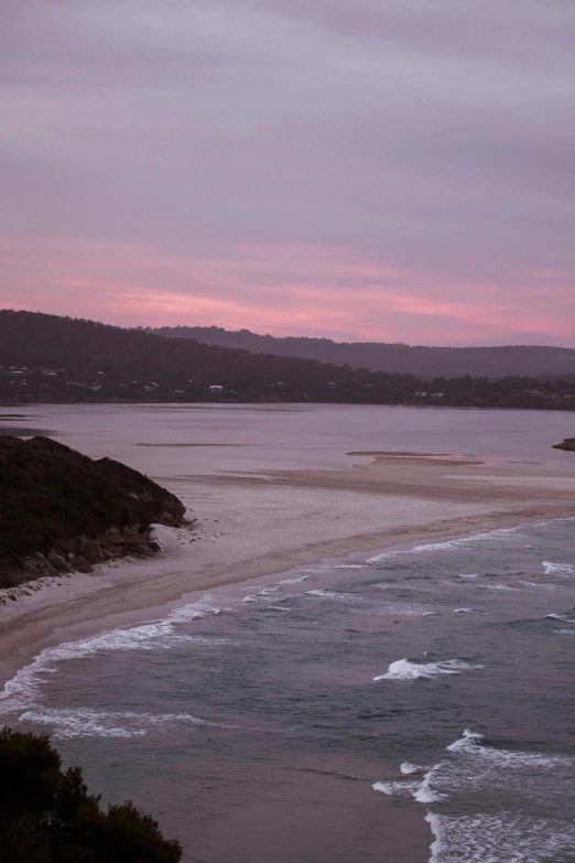 a large body of water next to a beach, unsplash, australian tonalism, pink, beach is between the two valleys, late evening, lit from above