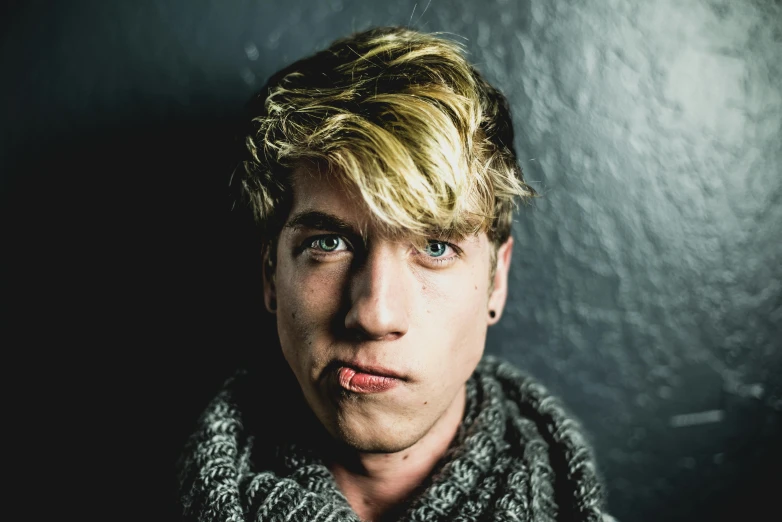 a close up of a person wearing a scarf, by Jacob Toorenvliet, unsplash, avatar with a blond hair, ugly look, cute young man, multiple lights