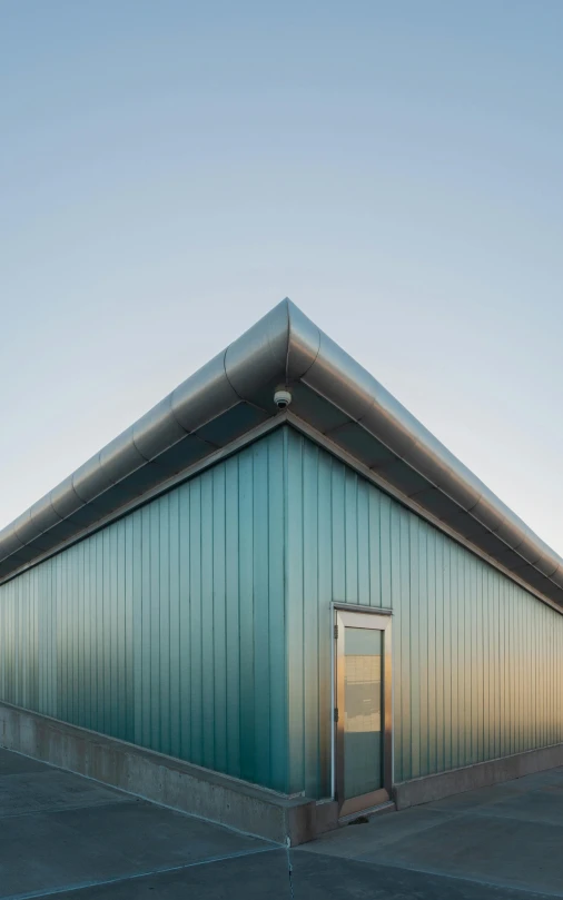 a blue building with a red fire hydrant in front of it, an album cover, inspired by Tadao Ando, unsplash, shot at golden hour, galvalume metal roofing, profile view perspective, cyan and green