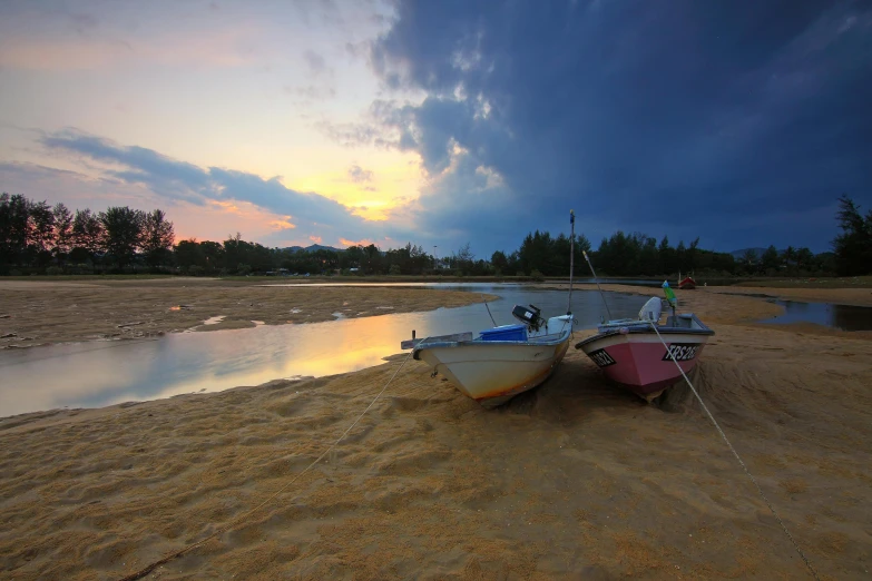 a couple of boats sitting on top of a sandy beach, a picture, by Basuki Abdullah, hurufiyya, golden hour photo, thomas river, ultrawide image, fan favorite