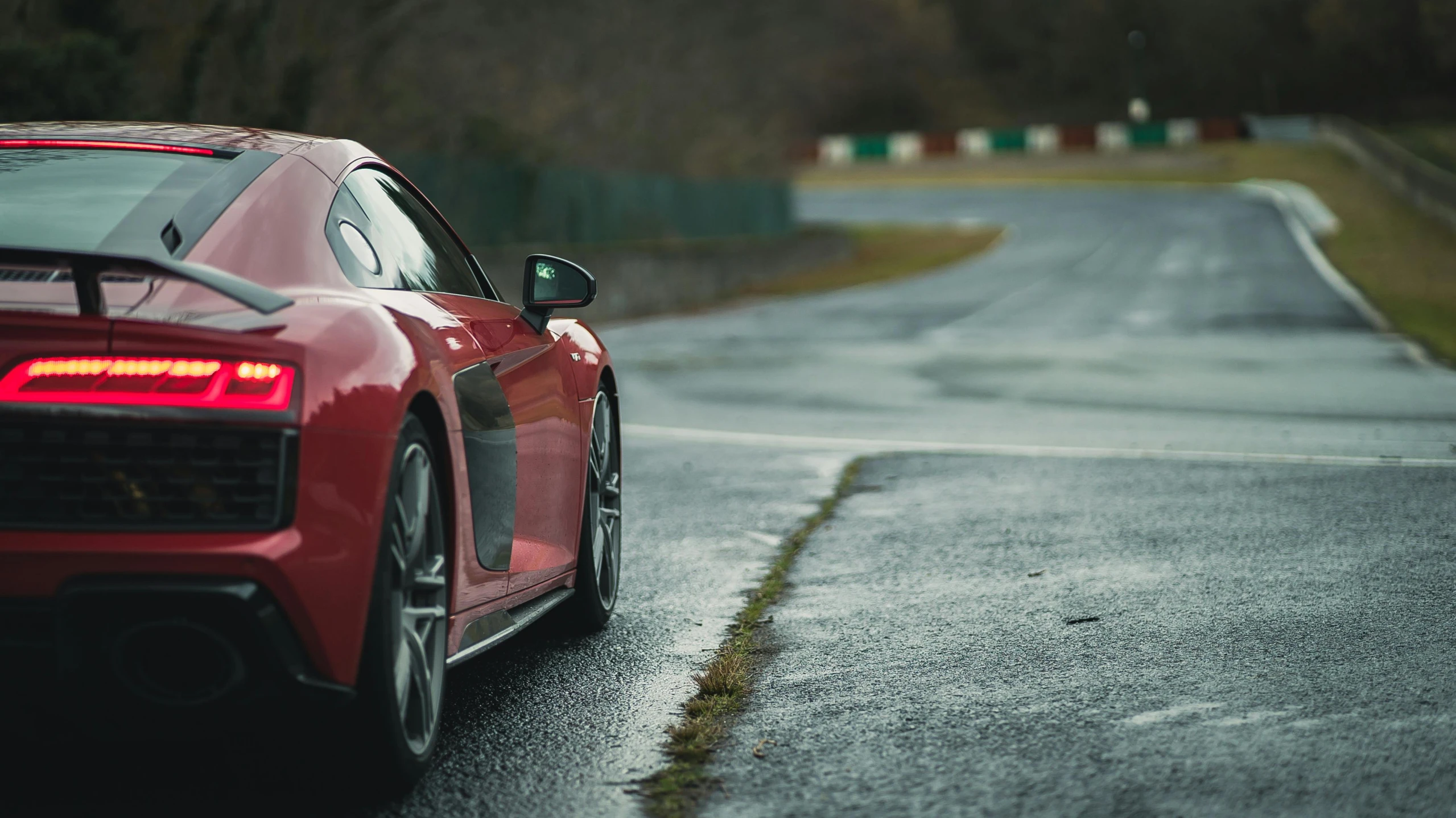 a red sports car driving down a wet road, inspired by Harry Haenigsen, unsplash, at circuit de spa francorchamps, wide angle”, fujifilm”