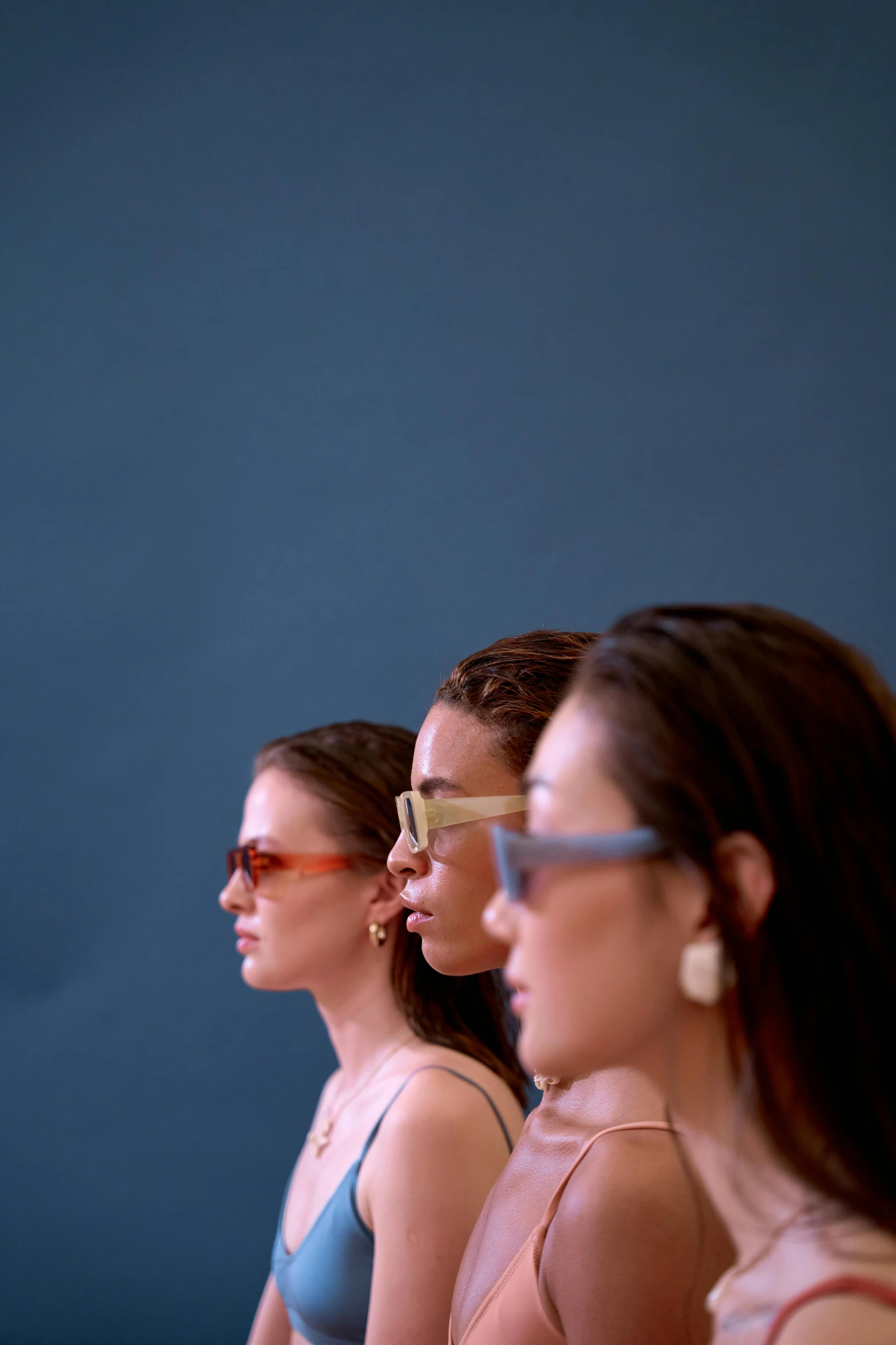 a group of women standing next to each other, by Nina Hamnett, visual art, blue sunglasses, side profile view, focus on model, tan complexion