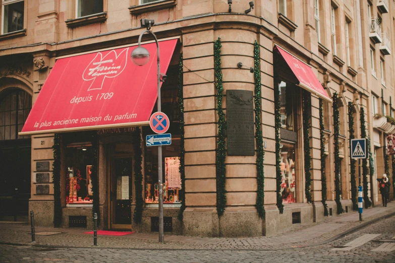 a red awning on the side of a building, by Julia Pishtar, pexels contest winner, art nouveau, dressed in red paper bags, cobblestone street, new balance pop up store, 2 5 6 x 2 5 6 pixels