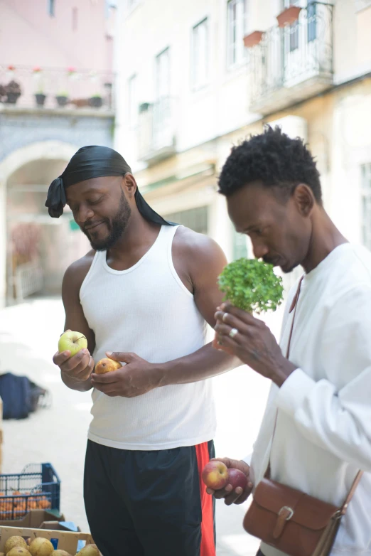 a couple of men standing next to each other, by Ingrida Kadaka, trending on unsplash, renaissance, local foods, macron with afro hair, eating rotting fruit, lettuce