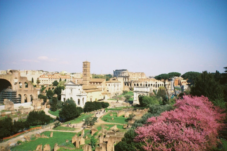 a view of a city from the top of a hill, an album cover, inspired by Augustus Dunbier, pexels contest winner, neoclassicism, pink marble building, ( ( ruins of ancient rome ) ), flowers around, kodak portra