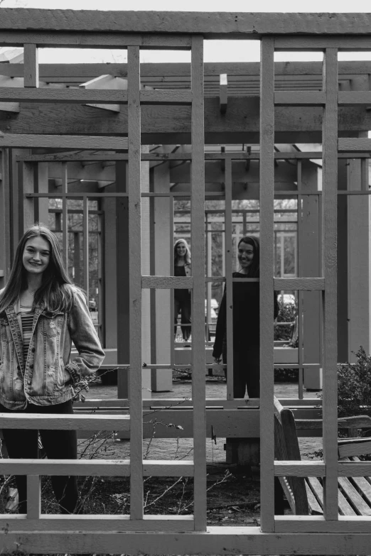 a black and white photo of a woman sitting on a bench, a black and white photo, cages, mirrored, both smiling for the camera, standing upright like people