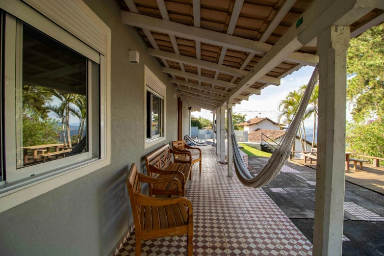 a hammock hanging from the side of a house, inspired by Samuel Silva, pexels contest winner, panorama view, azulejo, with a front porch, avatar image