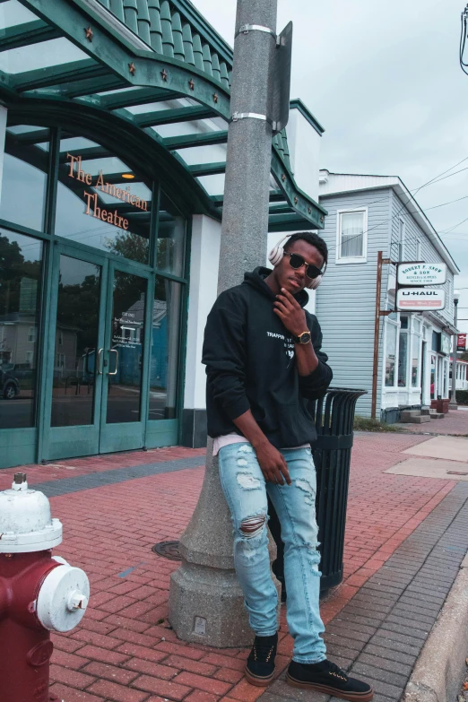 a man standing next to a red fire hydrant, an album cover, trending on unsplash, playboi carti portrait, small town, wearing shades, rhode island