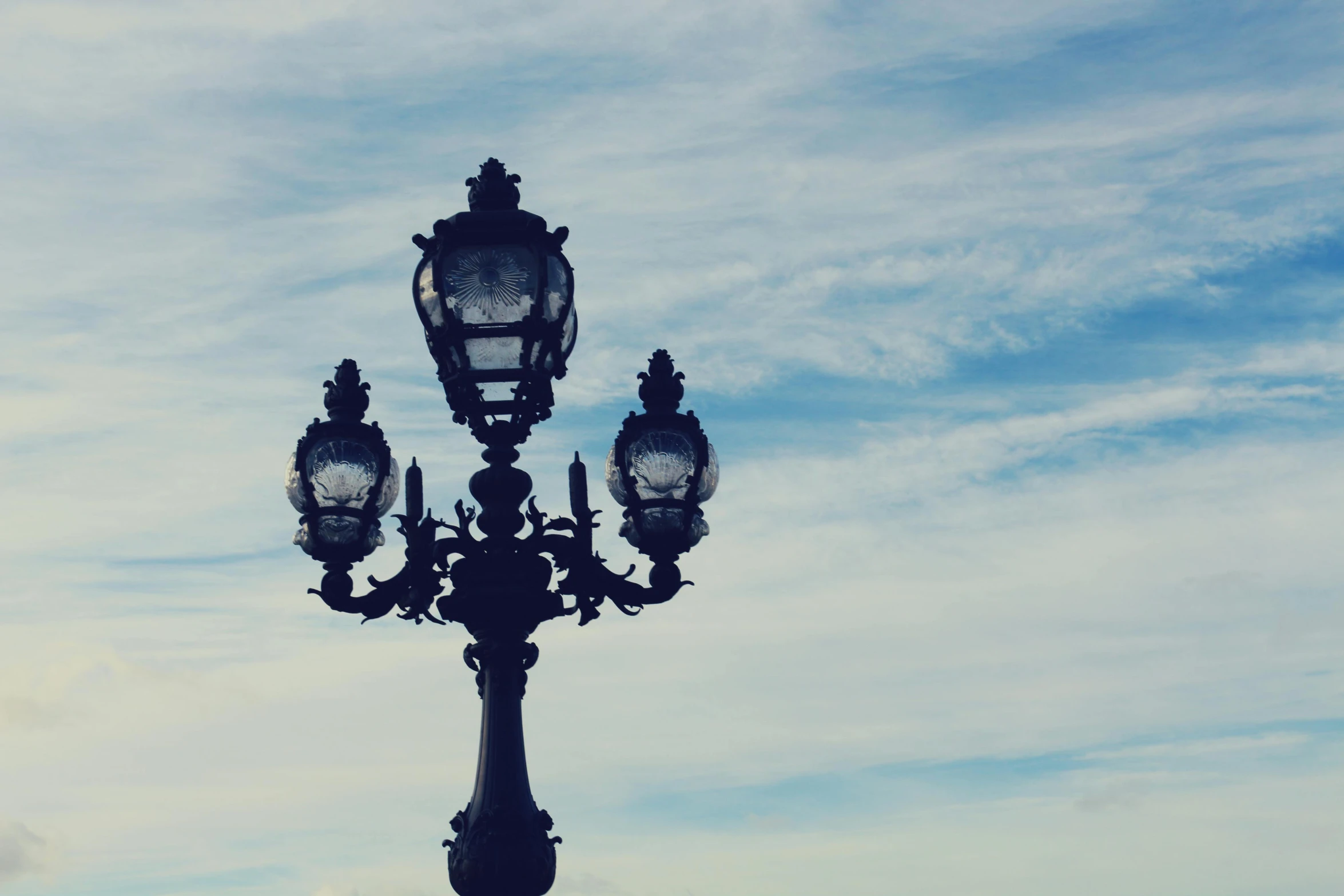 a street light sitting on the side of a road, unsplash, baroque, light blue sky, chandeliers, square, paris background