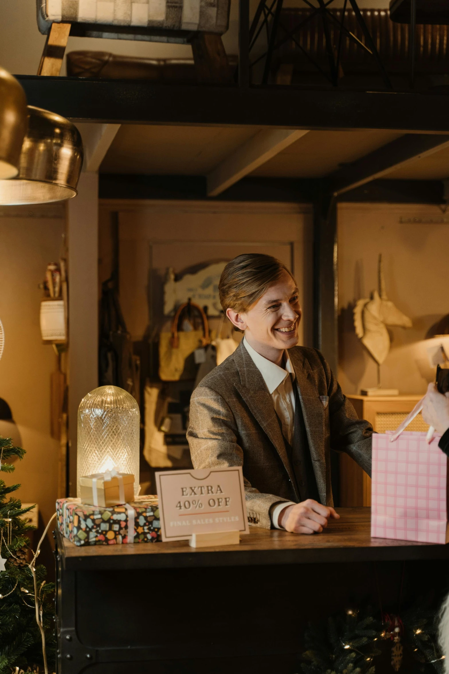 a man and a woman standing in front of a christmas tree, at checkout, emma watson smiling, wes anderson film, evening sun