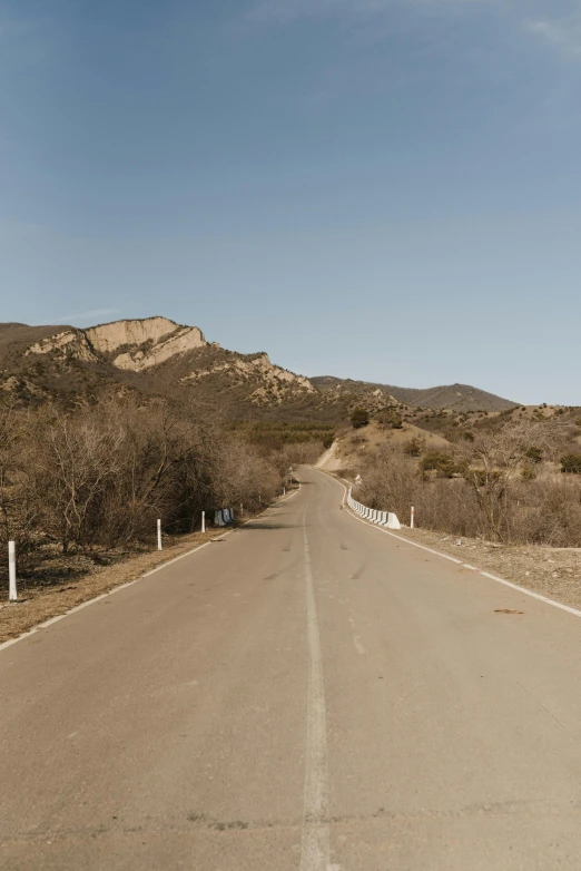 a man riding a skateboard down the middle of a road, by Ryan Pancoast, les nabis, 4k panoramic, hollister ranch, desolate :: long shot, sparsely populated