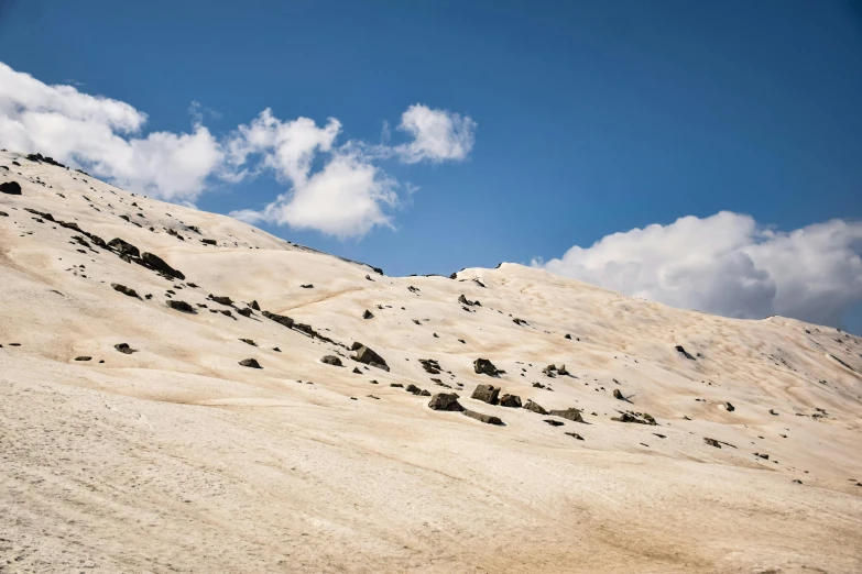 a man riding a snowboard down a snow covered slope, an album cover, trending on unsplash, les nabis, in the dry rock desert, landslides, ceremonial clouds, white stone