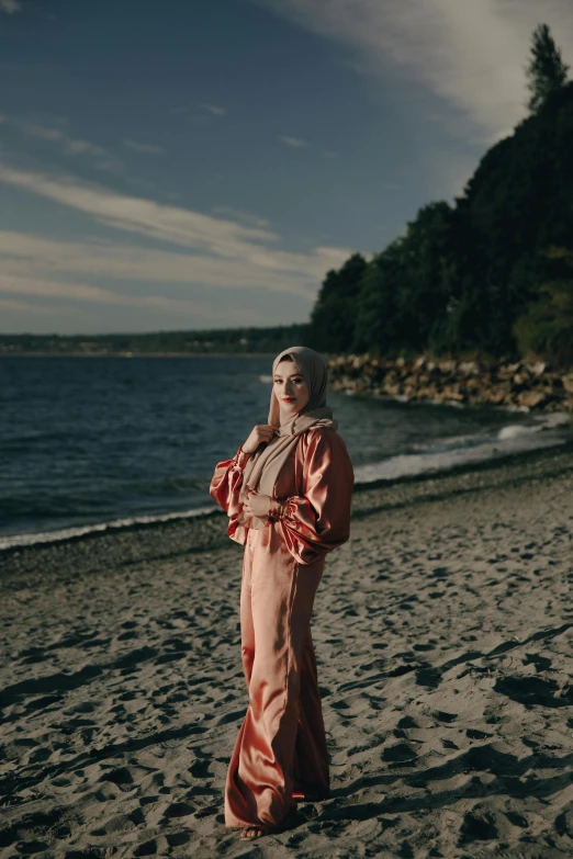 a woman standing on top of a sandy beach, an album cover, inspired by Elsa Bleda, unsplash, renaissance, wearing a light - pink suit, a full portrait of nordic female, wearing a track suit, modest