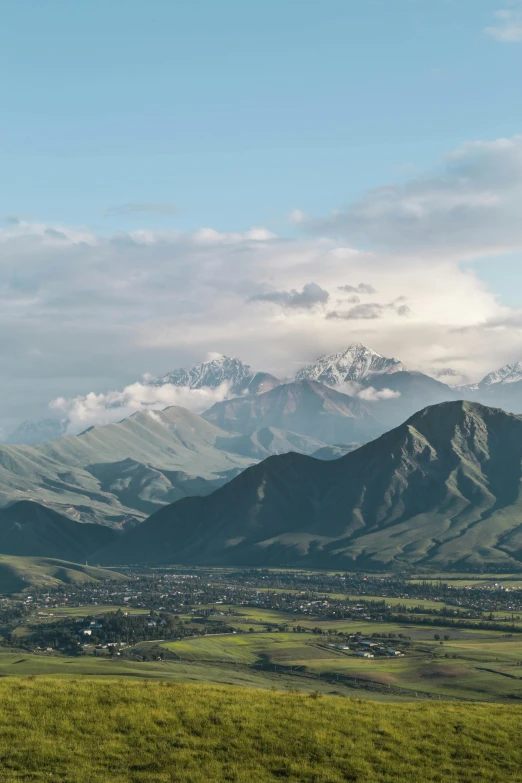 a view of a valley with mountains in the background, by Daren Bader, unsplash contest winner, hurufiyya, samarkand, “ aerial view of a mountain, conde nast traveler photo, lush