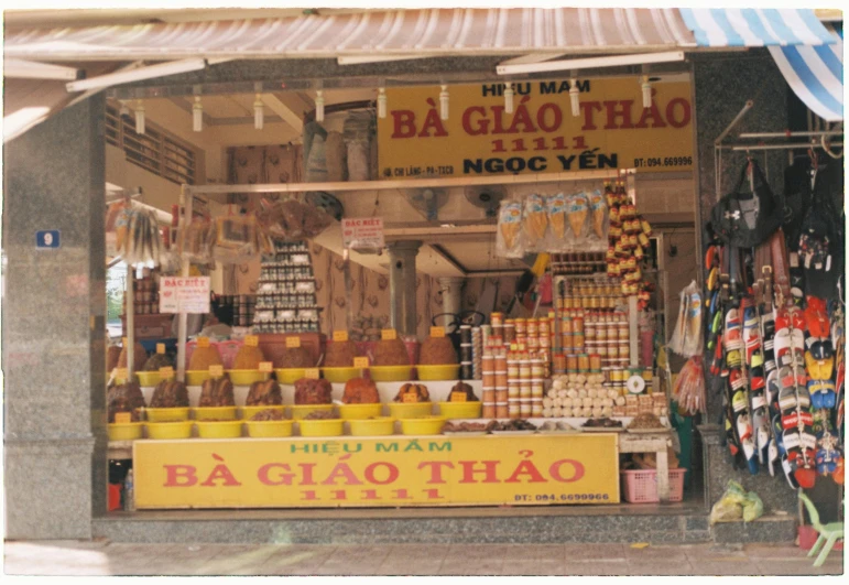 a store front with a sign that says ba bao bao bao bao bao bao bao bao bao bao bao bao bao bao bao bao, an album cover, dau-al-set, taken with polaroid kodak portra, vietnamese temple scene, yellow and ornage color scheme, market stalls