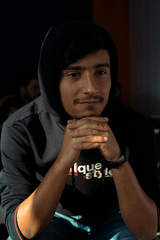 a man sitting in front of a laptop computer, inspired by Alonso Vázquez, featured on reddit, realism, wearing a black hoodie, proud serious expression, mogul khan, profile image