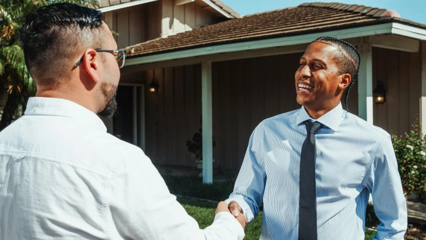 two men shaking hands in front of a house, pexels contest winner, gus fring, looking happy, background image, hispanic