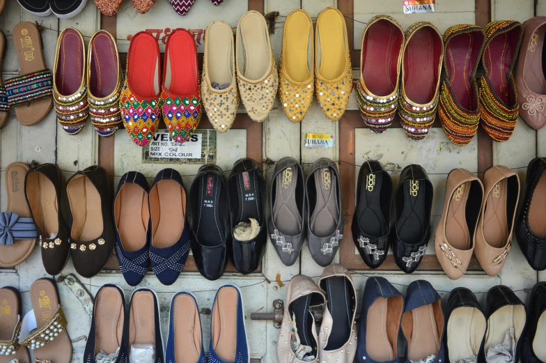 a wall filled with lots of different types of shoes, by Gina Pellón, trending on pixabay, on an indian street, 🦩🪐🐞👩🏻🦳, black loafers, colored market stand