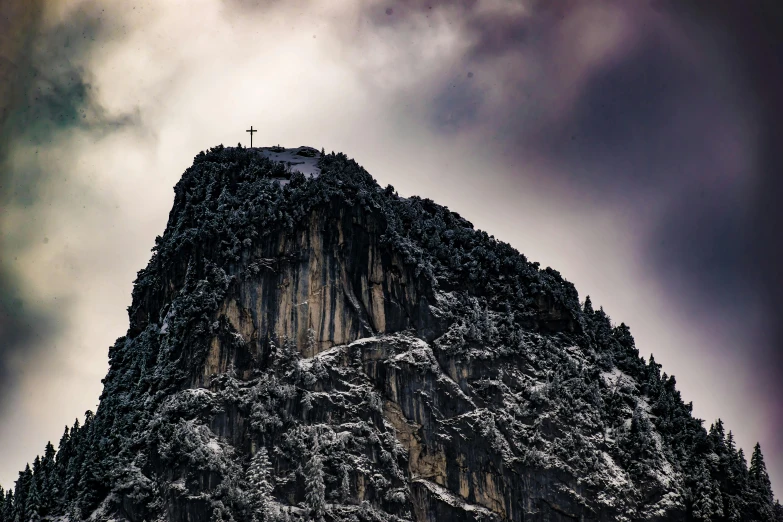 a mountain with a cross on top of it, pexels contest winner, romanticism, on a dark winter's day, big sharp rock, postprocessed, slide show