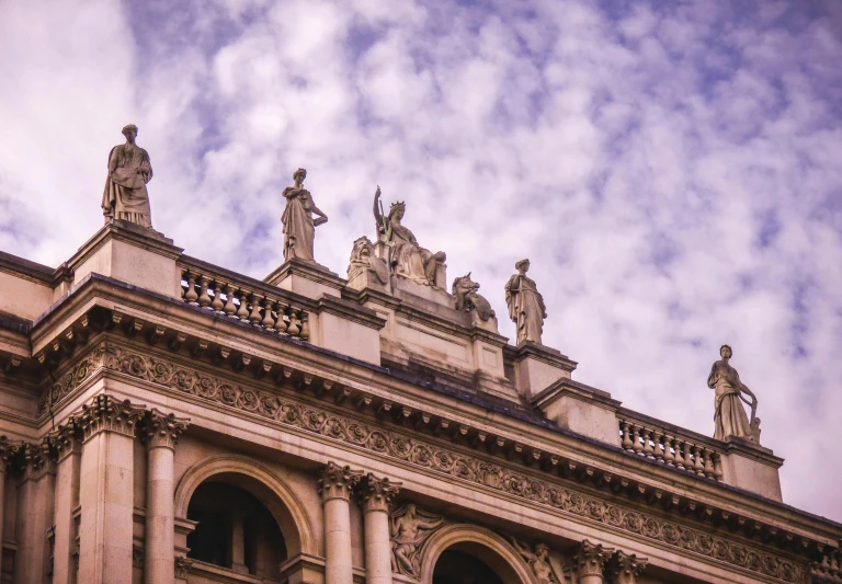 a large building with statues on top of it, inspired by Hubert Robert, pexels contest winner, shot from roofline, old library, skies, bernini