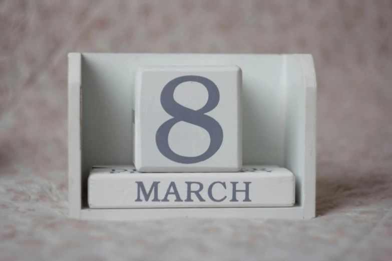 a wooden block with the number eight on it, a picture, by Felicity Charlton, trending on unsplash, happening, beware the ides of march, silver，ivory, female calendar, with a long white