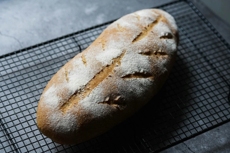 a loaf of bread sitting on a cooling rack, a portrait, unsplash, pointè pose, front facing shot, whole-length, smooth oval head