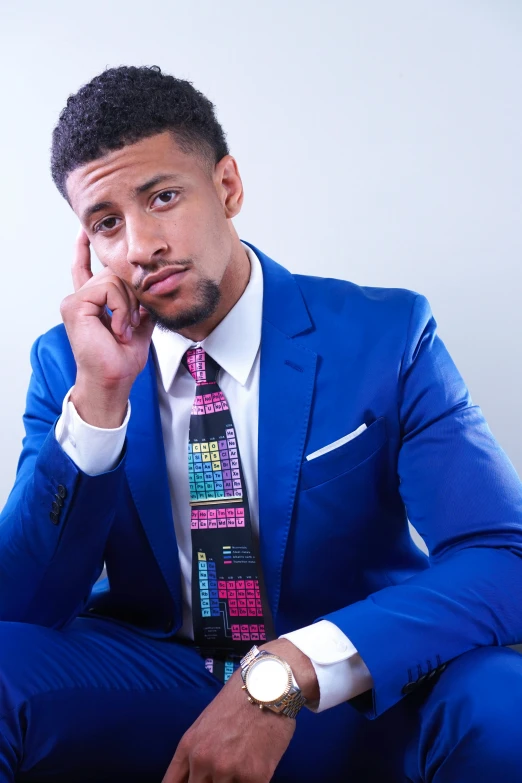 a man in a blue suit sitting on a chair, inspired by Frank Mason, featured on instagram, wearing a colorful men's suit, dylan cole, on clear background, necktie