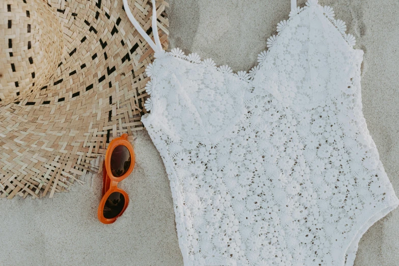 a white one piece swimsuit next to a straw hat and sunglasses, pexels contest winner, plasticien, white and orange, white lace, background image, detailed lace dress