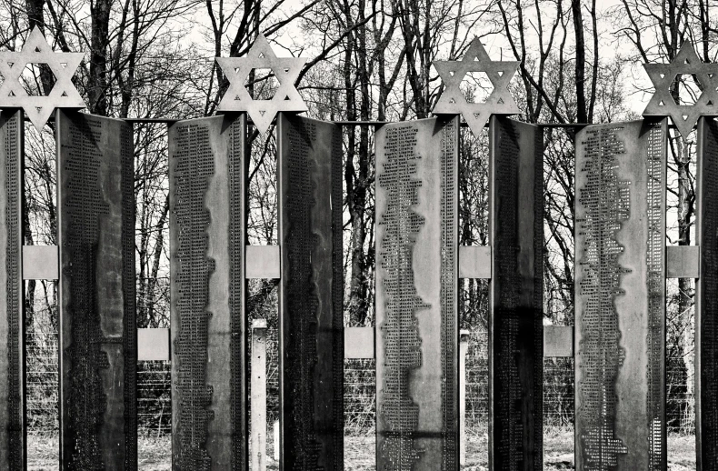 a black and white photo of a fence with stars on it, a black and white photo, inspired by Kees Scherer, berlin secession, shrines, rusted panels, dug stanat, a wooden