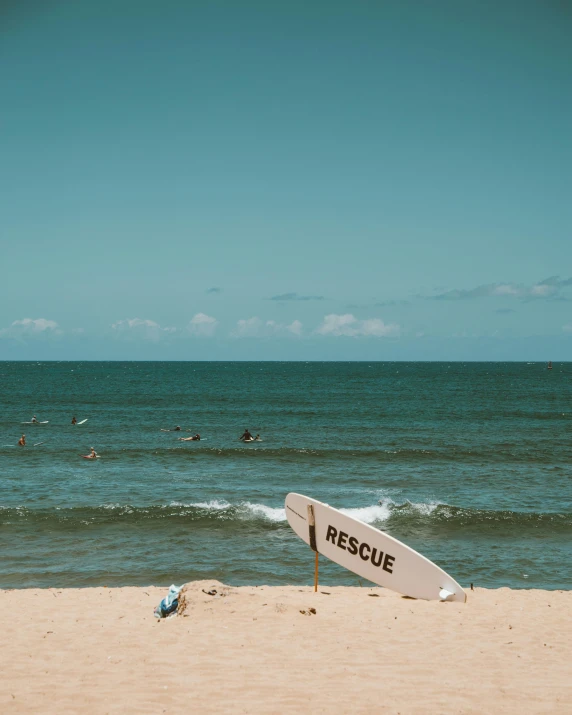 a white surfboard sitting on top of a sandy beach, pexels contest winner, renaissance, subject action : holding sign, people swimming, lgbtq, thumbnail