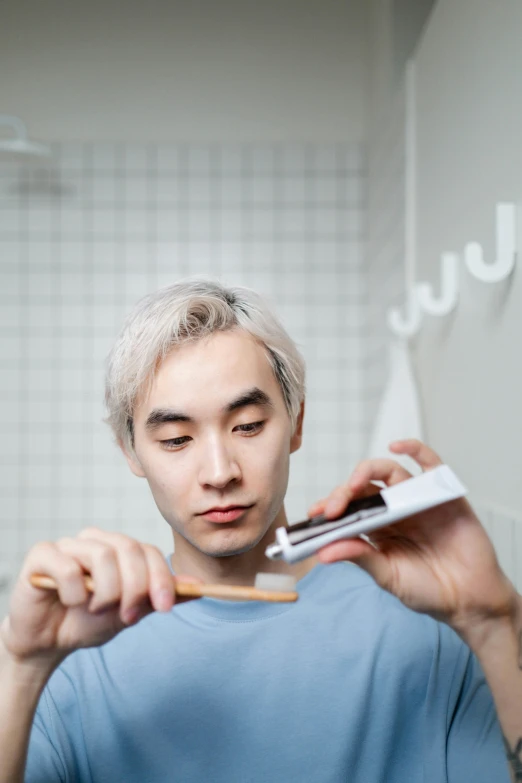 a man brushing his teeth in the bathroom, an album cover, inspired by jeonseok lee, trending on pexels, happening, platinum hair, non binary model, 15081959 21121991 01012000 4k, asian face