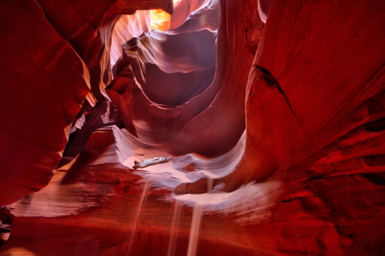 the sun shines through a narrow slot in antelope canyon, arizona, by Jessie Algie, pexels contest winner, art nouveau, 2022 photograph, cave with waterfall, reddish, photorealist