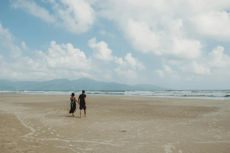 a couple of people standing on top of a sandy beach, vietnam, background image, walking to the right, ignant