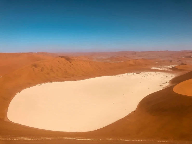 a large body of water sitting in the middle of a desert, inspired by Scarlett Hooft Graafland, pexels contest winner, land art, craters, youtube thumbnail, in an arena in movie dune-2021, landscape of africa