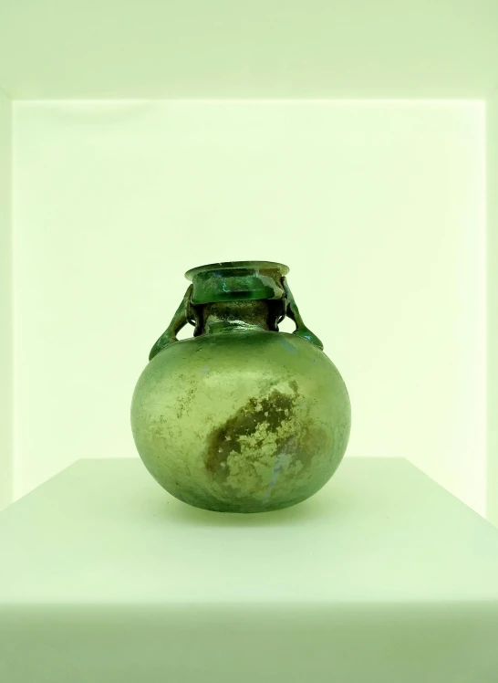 a green vase sitting on top of a white shelf, by Louis Comfort Tiffany, mingei, wide high angle view, ignant, hgrenades, 4 0 0 bc