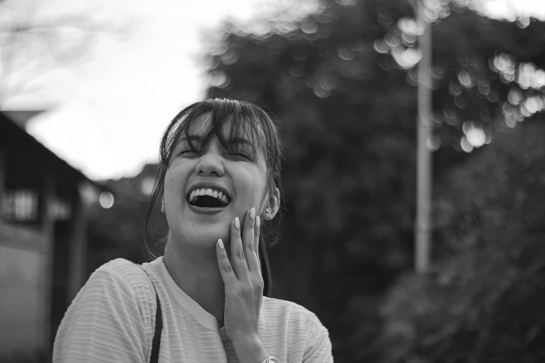 a woman laughing while talking on a cell phone, a black and white photo, by Emma Andijewska, unsplash contest winner, happening, young cute wan asian face, 🤤 girl portrait, 4 5 mm bokeh, happy friend
