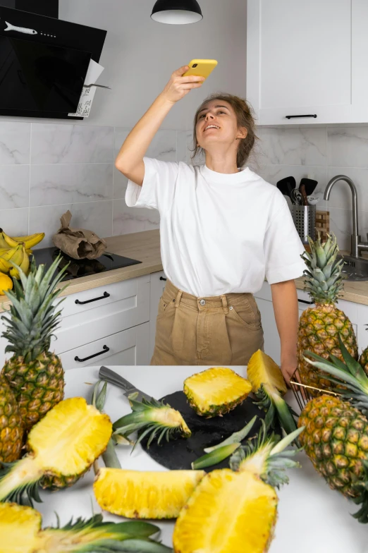 a woman standing in a kitchen surrounded by pineapples, by Julia Pishtar, pexels contest winner, dabbing, sentient fruit, young woman looking up, profile image