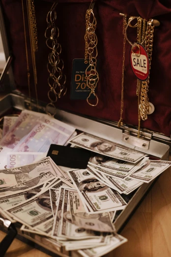 a suitcase filled with lots of money sitting on top of a table, jewelry display, clothing drop, 2019 trending photo, 10k