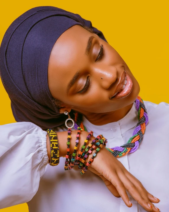 a woman wearing colorful bracelets and a turban, an album cover, trending on pexels, hurufiyya, essence, islamic, maria borges, lgbtq