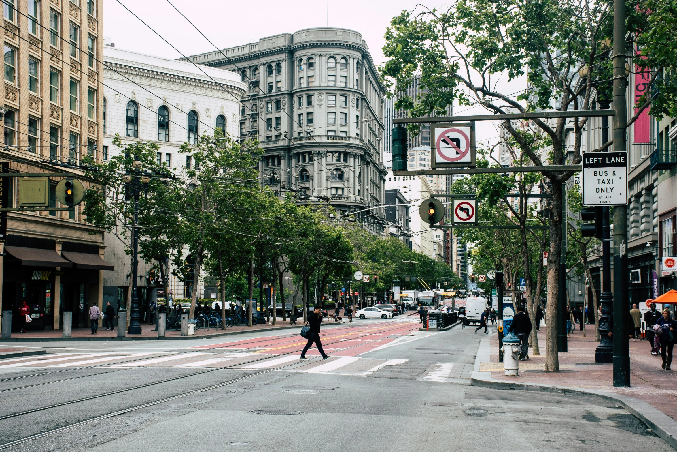 a street filled with lots of traffic next to tall buildings, by Nina Hamnett, unsplash contest winner, renaissance, sf, on a great neoclassical square, san mumford, street signs