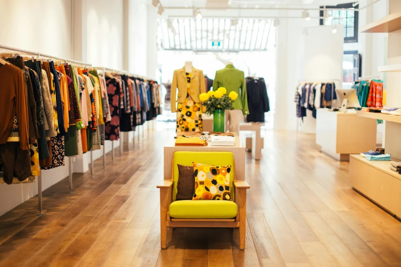 a brightly colored chair in a clothing store, by Nicolette Macnamara, pexels, yellow carpeted, lush vista, walking down, thumbnail