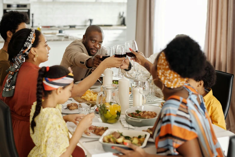 a group of people sitting around a dinner table, black people, holding a glass of wine, profile image, families playing