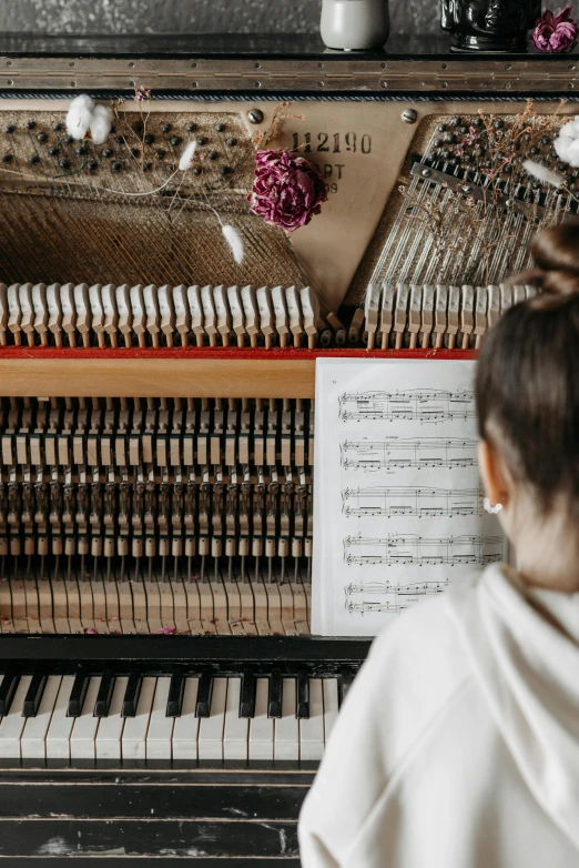 a little girl standing in front of a piano