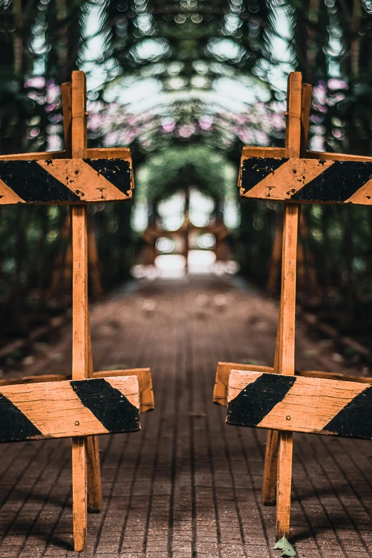 a couple of wooden signs sitting on top of a wooden floor, a picture, pexels contest winner, abstract illusionism, gate, archways made of lush greenery, danger, [ cinematic