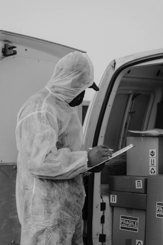 a man in a hazmat suit standing next to a van, a black and white photo, by Adam Marczyński, pexels, writing on a clipboard, wearing lab coat and a blouse, inspect in inventory image, profile picture 1024px