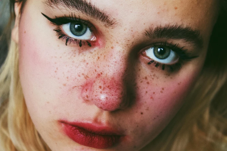 a close up of a woman with freckles on her face, a stipple, inspired by Elsa Bleda, trending on pexels, sadie sink, as well as scratches, beautiful grumpy girl, human face with bright red yes